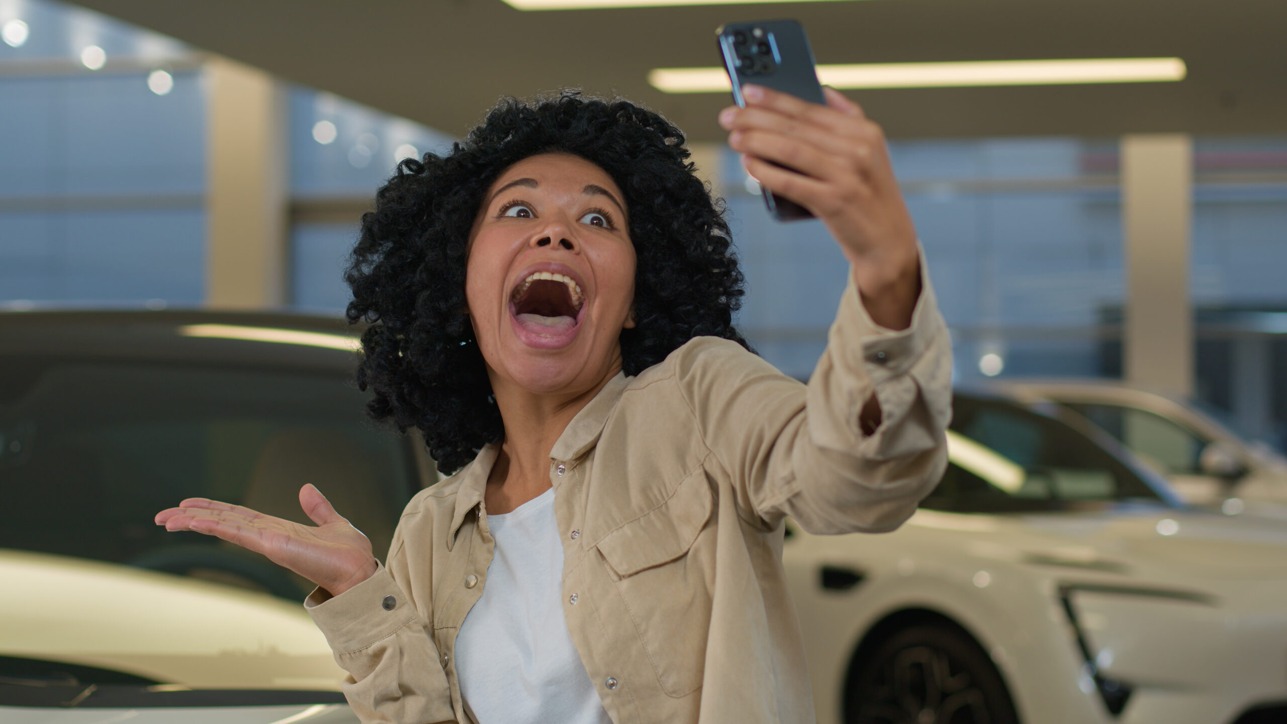 joyful girl african american woman blogger taking selfie photo car showroom buying new auto dealership salon happy cheerful client buyer blogging with smartphone advertising automobile vehicle scaled
